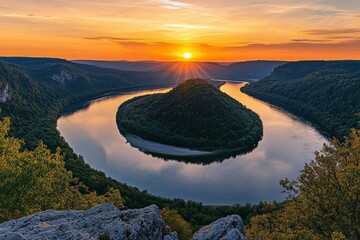 Poster - A breathtaking sunset illuminates a winding river surrounded by dense green forests, creating a dramatic and serene natural landscape under a glowing sky.