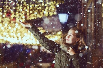 A teenage girl in a night city decorated for Christmas or New Year