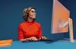 © Jacob Lund - Mature woman in eyeglasses and headset working at desk while communicating