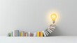 © NKCoolper - A spiral staircase formed by stacks of books leading up to a glowing light bulb symbolizing the transformative power of knowledge and the innovative solutions it can inspire