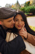 © LIGHTFIELD STUDIOS - A couple shares a tender moment in autumn, wrapped in warm clothes surrounded by colorful leaves.