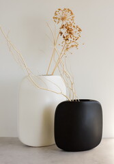 Canvas Print - Modern black and white ceramic vases with dry flower grass on white  background with sunlight shadow.Copy space, Aesthetic minimalist scandinavian interior accessories. 