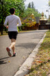 © Guys Who Shoot - on the street in the park in the city center a handsome brunette guy in black shorts and white sweater on a morning jog