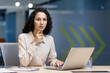 © Liubomir - Confident businesswoman sitting at office desk working on laptop. Represents professionalism, leadership, and focus in modern workplace. Ideal for themes of business, technology, and determination.