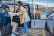 © Dragana Gordic - Young Woman Assisting Elderly Lady out of Car at Parking Lot