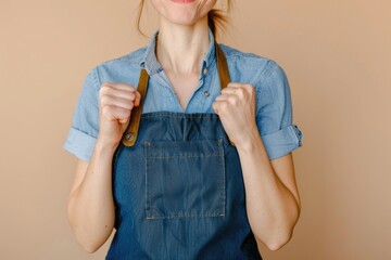 Poster - A woman wearing blue shirt and denim overalls holds a pair of scissors, ready for a creative task