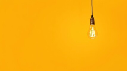 Bright glowing yellow light bulb casting light on a white background, white, innovation