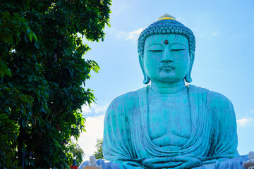 Wall Mural - The Great Buddha Simulate (Daibutsu or Great Buddha of Kamakura) stucco  Buddha statue at  Wat Phra That Doi Phra Chan in the city of Mae Tha in Lampang North of Thailand, travel Unseen Thailand