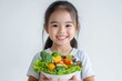 © CreativeLight - A child happily holding a plate filled with a variety of colorful fruits and vegetables, promoting healthy eating habits and nutrition, perfect for content focused on and wellness