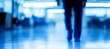 © Ilja - Businessman Walking in Blue Toned Modern Office Interior, Motion Blur, Corporate Life Concept