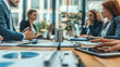 © tiagozr - Business people discussing finances in a corporate meeting.