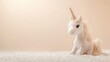 © Ahmad - Plush fabric and wool come together to create a charming little unicorn positioned against a plain creamy background, offering a delightful photo style with ample copy space.