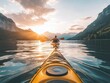 © shooreeq - Sunset view of a person kayaking in a calm lake surrounded by mountains, golden light