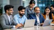 © N7 - A diverse group of Indian IT specialists brainstorming around a conference table with laptops and documents.