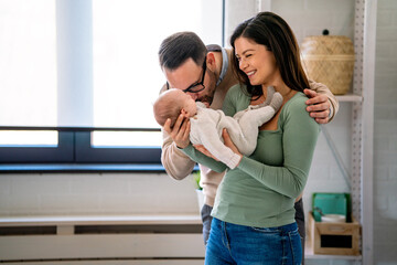 Wall Mural - Family love parenthood baby concept. Parents spend happy moments with the newborn child