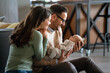 © NDABCREATIVITY - Smiling mother and father holding their newborn baby daughter at home