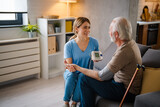 Young Nurse Checking Blood Pressure of Older Man at Home