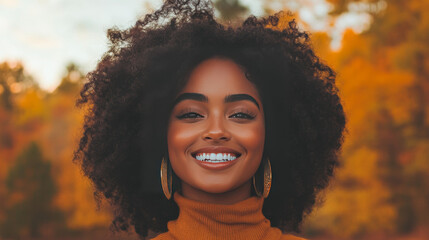 Wall Mural - A young Black woman with a warm smile stands in front of a blurred autumn background.