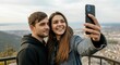 © volga - Young couple taking selfie with smartphone on scenic overlook