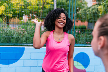 Happy black woman playing pickleball with friends outdoors