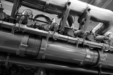 Poster - A large engine with many parts. The engine is made of metal and has many pipes and valves. The concept of industrialization and complexity of machines