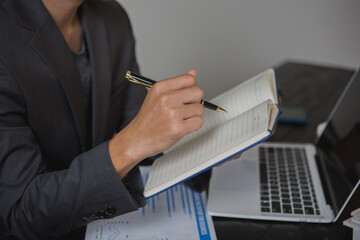 An Asian man works late at his desk papers, determined to meet his deadlines.