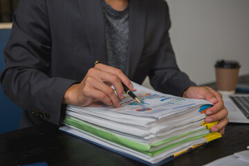 An Asian man works late at his desk papers, determined to meet his deadlines.