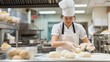 © acnaleksy - culinary student kneading dough in a brightly lit, modern kitchen classroom