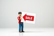 © ALEXEY FILATOV - toy man holding a sign with the text (Sale)