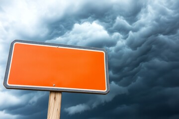 Wall Mural - Blank orange sign against a stormy sky.