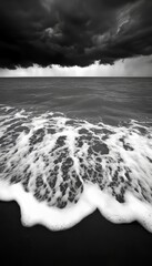 Wall Mural - Dramatic black and white image of a stormy sea with crashing waves on a sandy shore.