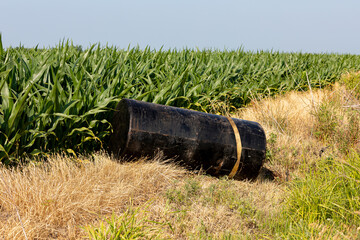 fuel tank dumped in ditch along road. fly dumping, environmental pollution, and hazardous waste mate