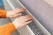 © Sabineyro - female hands are warming themselves near the radiator