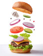 © Saddha Visual - burger with flying to much ingredients floating or flying isolated on clean white background