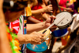 Mãos tocando tamborim, pandeiro e tambor no Carnaval de Rua de São Paulo. 