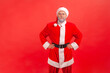 © khosrork - Adult man with gray beard wearing santa claus costume thinking over dilemma, making decision or difficult choice, contemplating idea, looking away.