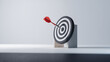 © Hound - A red arrow is shot through a black and white target. Concept of focus and determination, as the arrow pierces through the center of the target. The contrast between the red