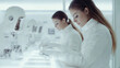 © Phuwadon - Two scientists in white lab coats working with advanced technology in a modern lab environment.