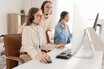 Wall Mural - Female technical support agents working at table in office