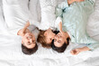 © Pixel-Shot - Little girl with her parents lying on bed, top view