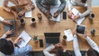 © Prostock-studio - Office lifestyle concept. Top view of international young business team having meeting at office, sitting around table