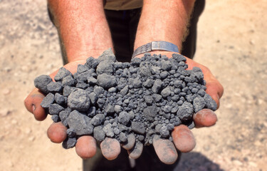 Sticker - Mine worker displays grey gravel sample