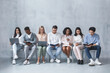 © Prostock-studio - Multiracial young group of people sitting in line and waiting for job interview, talking to each other and looking at laptops, panorama