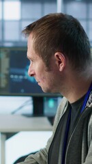 Poster - IT technician looking at PC screen, working in network security data center, ensuring optimal performance. Man supervising server hub, monitoring energy consumption across rigs, camera A