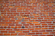 © Mint Images - Brick wall detail, old weathered red bricks laid in an irregular pattern.