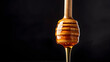 © Taras - A close-up shot of a honey dipper mid-drip, with golden Manuka honey slowly falling