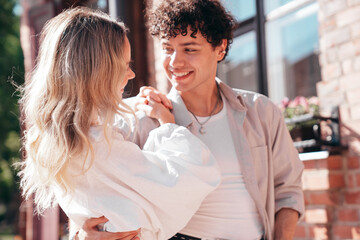 Smiling beautiful woman and her handsome boyfriend. Woman in casual summer clothes. Happy cheerful family. Female having fun. Couple posing in the street it sunny day. Cheerful and happy