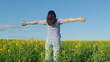 © artifex.orlova - Woman In A T-Shirt Standing In A Flowering Canola Rapeseed Field. Pretty Young Woman With Arms Raised In Air In Rapeseed Field.
