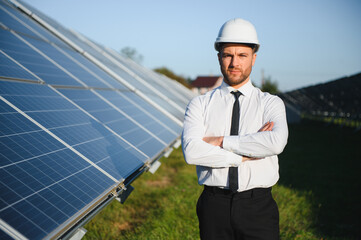 Solar power plant. Man standing near solar panels. Renewable energy