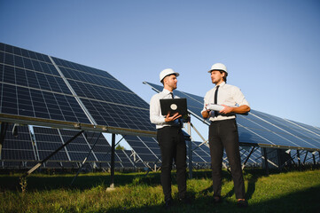 The solar farm, solar panel with two engineers walk to check the operation of the system, Alternative energy to conserve the world's energy, Photovoltaic module idea for clean energy production